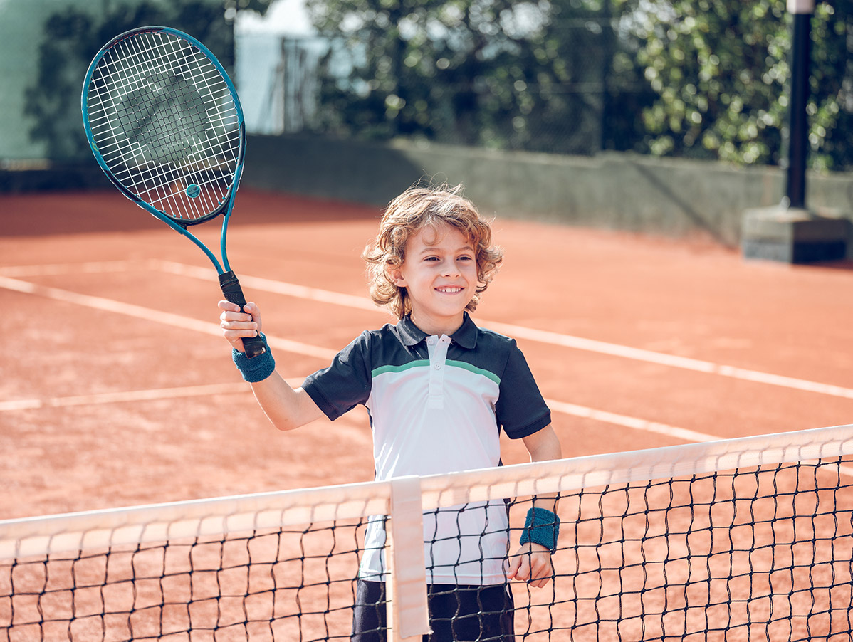 Niño jugando a tenis